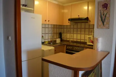 a kitchen with a white refrigerator and a counter at Apartamento Florazar 2, 10ºC Cullera in Faro de Cullera