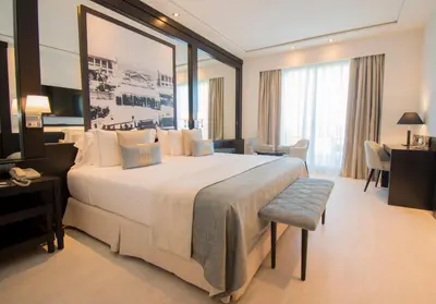 a hotel room with a large bed and a desk at Las Arenas Balneario Resort in Valencia