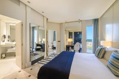 a bedroom with a king sized bed and a bathroom at Las Arenas Balneario Resort in Valencia