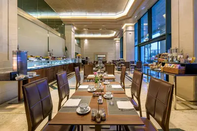 a restaurant with wooden tables and chairs and a bar at Las Arenas Balneario Resort in Valencia