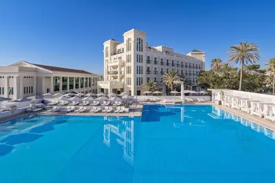 a large swimming pool with chairs and a hotel at Las Arenas Balneario Resort in Valencia
