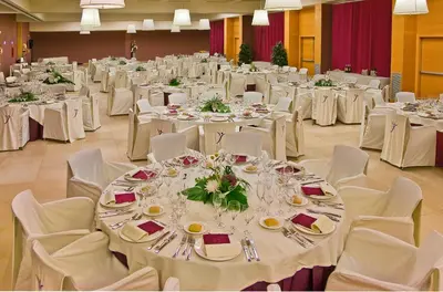 a banquet hall with white tables and white chairs at Silken Puerta Valencia in Valencia