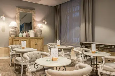 a room with tables and chairs and a mirror at Vincci Lys in Valencia