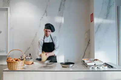a man in a kitchen preparing food at Hotel Neptuno Playa & Spa in Valencia