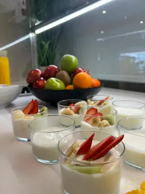 a table topped with bowls of food with fruit and candles at Hotel Neptuno Playa & Spa in Valencia