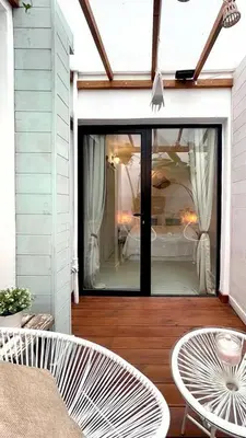 a patio with two chairs and a table and a bedroom at New Cozy Beach apartment, WiFi in Valencia