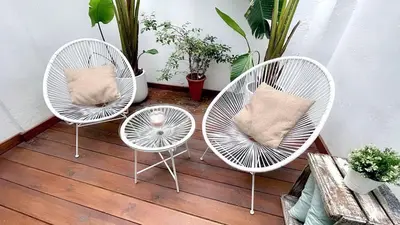 three white chairs with pillows sitting on a porch at New Cozy Beach apartment, WiFi in Valencia