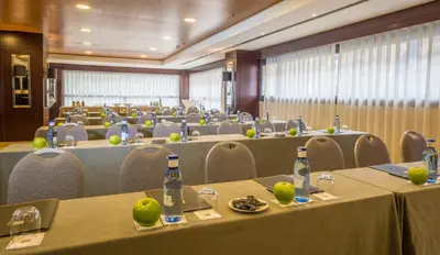 a large room with tables and chairs with bottles on them at Hotel Valencia Center in Valencia