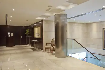 a lobby with a staircase and a shiny metal pole at Hotel Valencia Center in Valencia