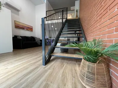 a living room with a staircase and a brick wall at Carbonell 1 in Valencia