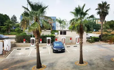 a car parked in a parking lot between two palm trees at Posadas De España Paterna in Paterna