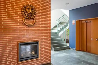 a fireplace next to a brick wall with a lion ornament at Posadas De España Paterna in Paterna