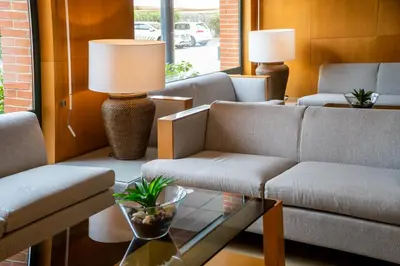 a living room with couches and a table with a lamp at Posadas De España Paterna in Paterna