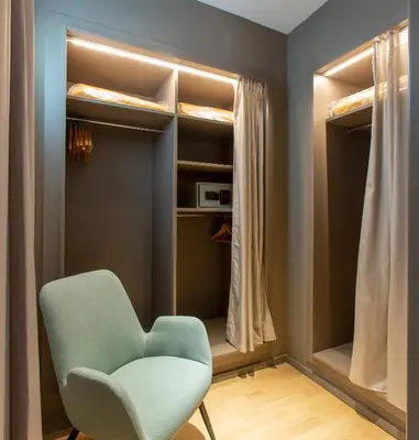 a room with a green chair in front of a closet at Hotel Olympia Valencia in Alboraya