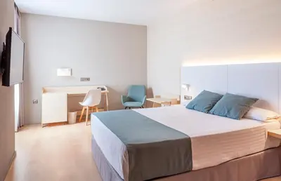 a bedroom with a large bed and a desk and a desk at Hotel Olympia Valencia in Alboraya