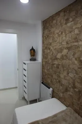 a bedroom with a stone wall and a white dresser at Apartamentos Alogia, Pastora, Yerbater in Segorbe