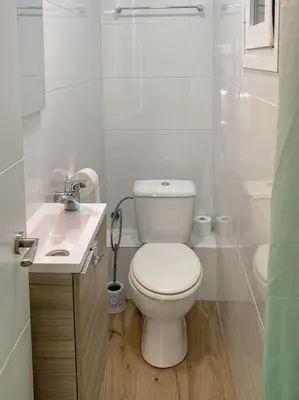 a white bathroom with a toilet and a sink at Vlc Center 4 Room Apartment in Valencia