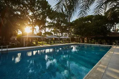 a swimming pool with chairs and umbrellas in a resort at El Oasis Villa Resort in La Eliana