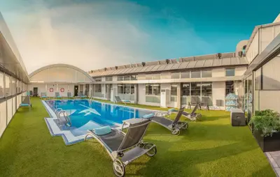 a swimming pool with lounge chairs in front of a building at SH Valencia Palace in Valencia