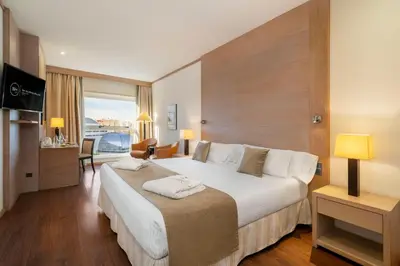 a hotel room with a large bed and a television at SH Valencia Palace in Valencia