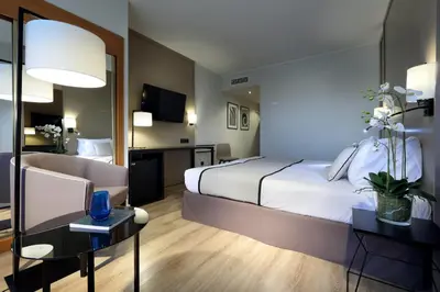 a hotel room with a bed and a desk and a room at Exe Rey Don Jaime in Valencia