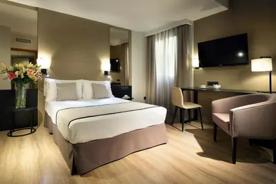 a hotel room with a bed and a desk at Exe Rey Don Jaime in Valencia