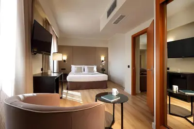 a hotel room with a bed and a chair at Exe Rey Don Jaime in Valencia