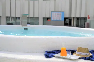 a swimming pool with a tray of bread and two glasses at Port Azafata Valencia in Manises
