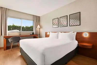 a hotel room with a large bed and a desk at Ramada by Wyndham Valencia Almussafes in Almussafes
