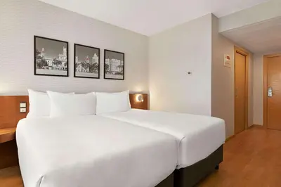 a large white bed in a hotel room at Ramada by Wyndham Valencia Almussafes in Almussafes