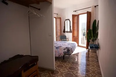 a bedroom with a bed and a door to a balcony at El mas allà in Chulilla