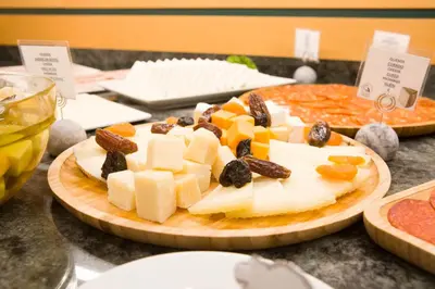 a plate of cheese and fruit on a table at Hotel Albufera in Alfafar