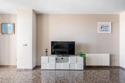 a living room with a tv and a white cabinet at Moderno apartamento con vistas al mar en Valencia in Valencia