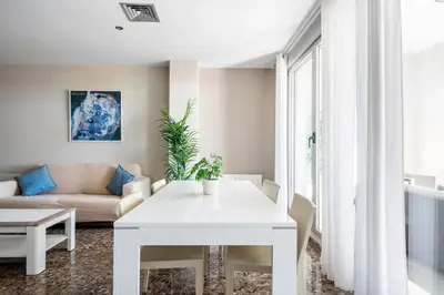 a living room with a white table and a couch at Moderno apartamento con vistas al mar en Valencia in Valencia