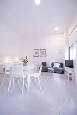 a white living room with a table and a couch at Viveros by Concept Flats in Valencia
