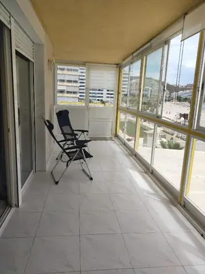 an empty balcony with two chairs and windows at Florazar 3 in Cullera