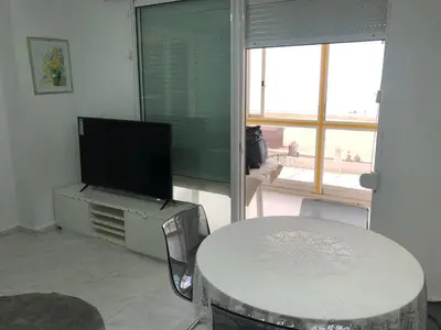 a living room with a tv and a table and a table and a television at Florazar 3 in Cullera