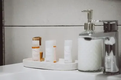 a group of bottles of moisturizers on a counter next to a sink at APARTAMENTOS LEO XIII in Valencia