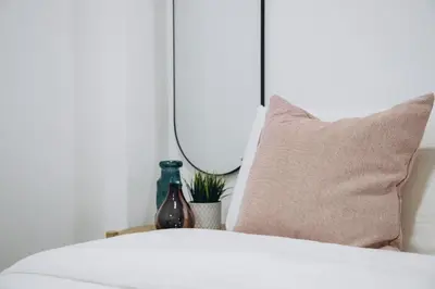 a bedroom with a bed with a pillow and a mirror at APARTAMENTOS LEO XIII in Valencia