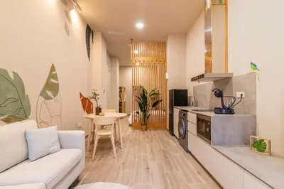 a living room with a white couch and a kitchen at Art Lofts Gardens in Valencia