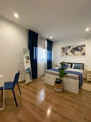 a bedroom with a bed and a table and a chair at Hostal Orange Vibes in Paterna