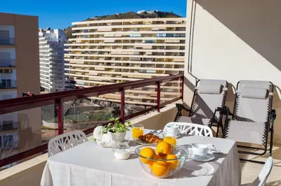 a table with a bowl of fruit on a balcony at Florazar Apartment Cullera Beachfront in Cullera