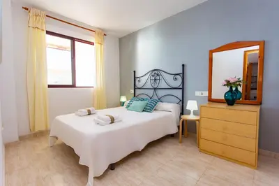 a bedroom with a bed and a mirror and a dresser at Florazar Apartment Cullera Beachfront in Cullera