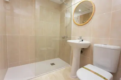 a bathroom with a toilet and a sink and a mirror at Florazar Apartment Cullera Beachfront in Cullera
