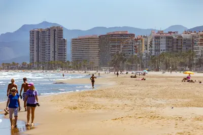 a group of people walking on a beach at Florazar Apartment Cullera Beachfront in Cullera