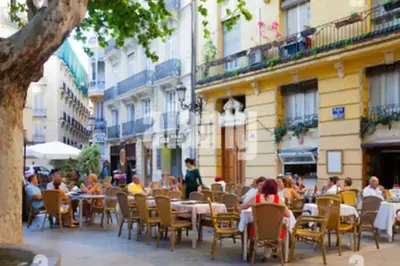 a group of people sitting at tables at an outdoor restaurant at amazing cozy apartment super central in Valencia