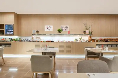 a restaurant with tables and chairs and a counter at Barceló Valencia in Valencia