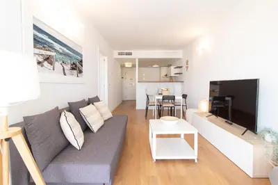 a living room with a couch and a tv at Global Vacacional, Moderno apartamento en Canet al Mar in Canet de Berenguer