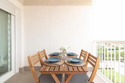 a wooden table with two chairs and a table with plates at Global Vacacional, Moderno apartamento en Canet al Mar in Canet de Berenguer