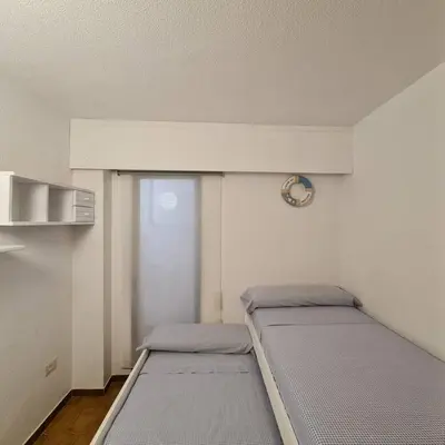 a small room with two beds in it at Precioso apartamento en Cullera, con piscina junto a la playa in Cullera